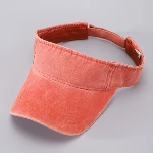 Close-up of washed red denim visor with reinforced stitching and adjustable strap
