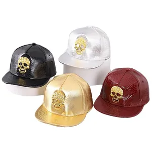 Flat brim hip hop caps in shiny faux leather with gold skull emblem decoration