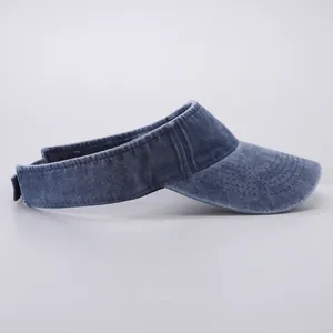 Detail view of washed denim fabric texture and parallel stitching on sun visor hat brim