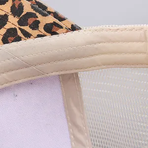 Macro detail of leopard print fabric with breathable mesh and stitching on ponytail baseball cap