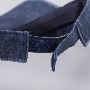 Detail of adjustable velcro strap and stitching on blue denim sun visor hat