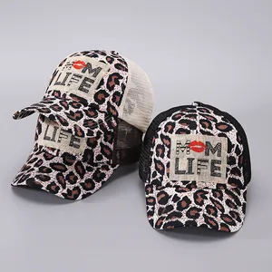 Detail van truckerpetten met luipaardprint, MOM LIFE-borduurwerk en mesh panelen