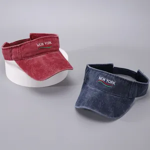 Detail of burgundy and navy sun visors with New York embroidery and washed cotton texture