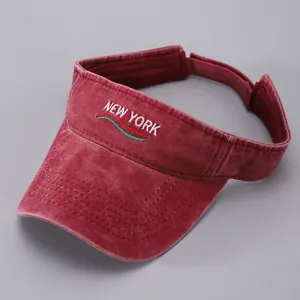 Detail of embroidered NEW YORK lettering on red washed cotton sun visor hat