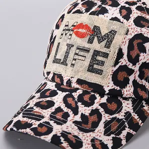 Detail van de baseballpet met luipaardprint, MOM LIFE-patch en rode lippen-icoon