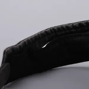 Detail of black fabric sun visor showing fine stitching and internal functional pocket