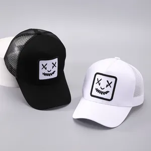 Détail de deux casquettes de camionneur avec broderie de visage souriant excentrique