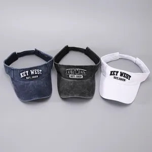 Three embroidered visor hats in navy blue, charcoal grey, and white with adjustable straps