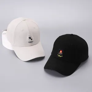 Detail of embroidered cloth labels on cotton baseball caps in beige and black colors