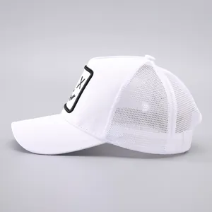 Vue latérale de casquette trucker blanche avec maille et écusson brodé carré signe X