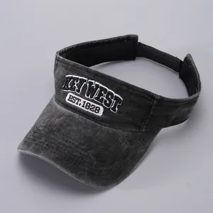 Detailed close-up of white letter embroidery on a washed dark gray cotton sun visor hat