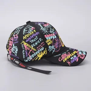 Close-up of graffiti print baseball cap with long strap and silver metal buckle detail