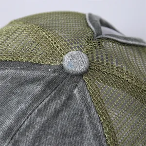 Dettaglio ravvicinato del tessuto lavato grigio scuro e cuciture a rete verde oliva sul cappello