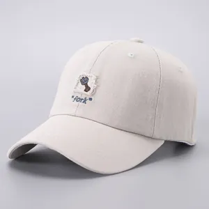 Detail of minimalist cotton baseball cap featuring a rustic frayed cloth fork patch