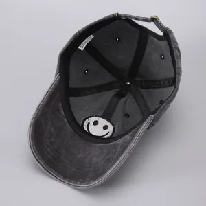 Detail of 100% cotton washed denim baseball cap with metal buckle and smiley patch