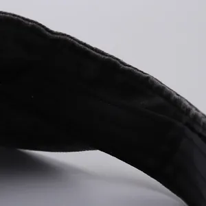 Close-up of high-density black fabric stitching on the brim of a summer sun visor cap