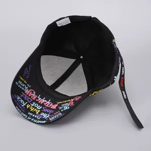 Detail view of cotton baseball cap featuring graffiti slogans and interior wash label