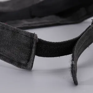 Detailed close-up of adjustable hook-and-loop strap on a black embroidered sun visor hat
