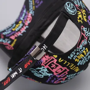 Detail of adjustable metal buckle and printed ribbon on black graffiti baseball cap