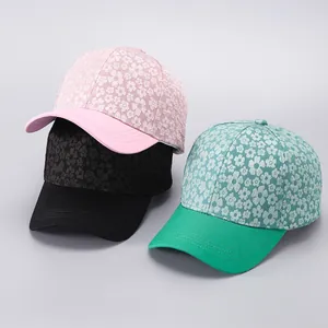 Detail of floral baseball caps showing pink, black and green patterns with curved brims