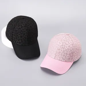 Detail of floral embossed texture and stitching on black and pink baseball caps