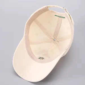 Detailed interior of a beige cotton baseball cap featuring reinforced seams and handmade label