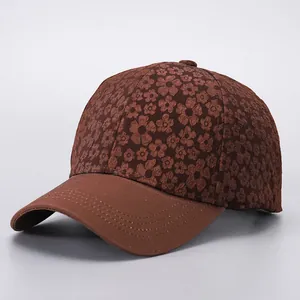 Macro detail of brown baseball cap with floral jacquard texture and stitched brim