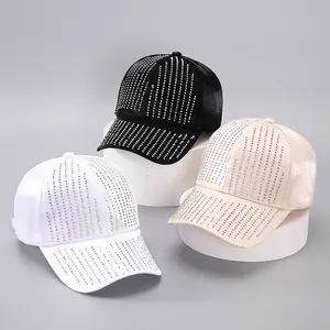 Close-up of sparkling rhinestone tassels on satin baseball caps in black, white and beige