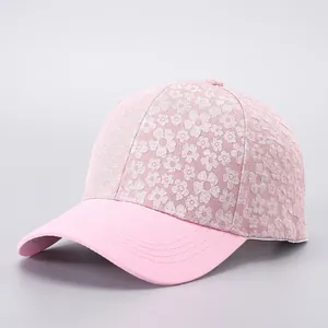 Detail of floral lace baseball cap showing delicate pink floral embroidery and brim