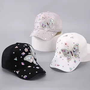 Detail von funkelnden Strass-Schmetterlingen und Blumen auf farbenfrohen Damen-Baseballkappen