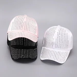 Close-up of pink, black, and white baseball caps featuring rows of sparkling rhinestones