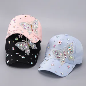 Detailansicht der Strass-Schmetterlingsmuster auf rosa, schwarzen und blauen Kappen