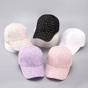 Detail view of lace baseball caps with rhinestone flowers in five assorted colors