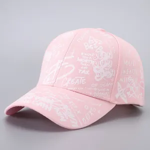 Close-up of pink baseball cap featuring white graffiti print and detailed cotton stitching