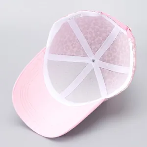 Detail view of pink baseball cap interior showing 100% polyester label and mesh lining