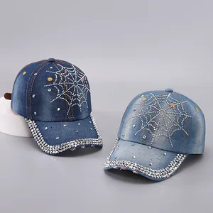 Detailed view of denim baseball caps with rhinestone spider web patterns in blue colors