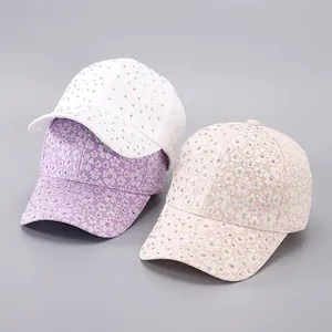 Close-up of lace baseball caps with floral embroidery and sparkling colorful rhinestones