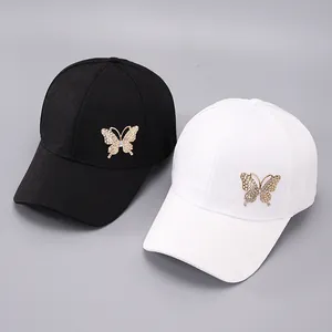 Close-up of black and white baseball caps featuring jacquard fabric and rhinestone butterflies