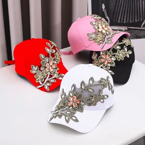 Detailansicht der Baseballkappen mit Strassblumen in Rot, Rosa, Weiß und Schwarz