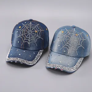 Close-up of rhinestone spider web patterns on blue washed denim baseball caps