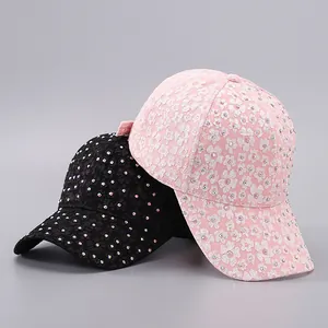 Detailed view of lace baseball caps with floral patterns and colorful rhinestones in two colors