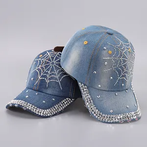 Detailed view of denim baseball caps with rhinestone spider web design and studded brim