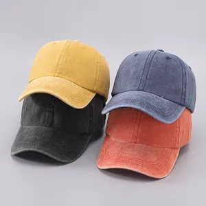 Stacked collection of washed cotton baseball caps in yellow, navy, black and orange