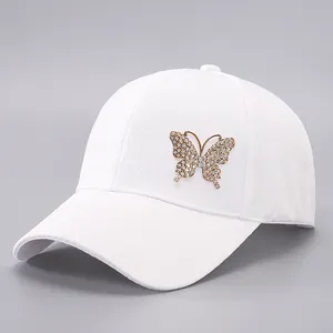 White baseball cap with jacquard floral pattern and a large rhinestone gold butterfly