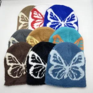 Dettaglio di berretti in maglia jacquard a farfalla in vari colori con trama morbida