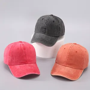 Macro shot of washed cotton baseball caps in grey, rose red and orange color palette