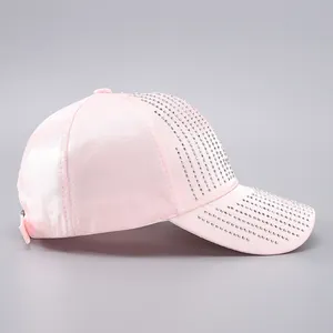 Detail of pink satin baseball cap featuring sparkling rhinestones on the side and brim