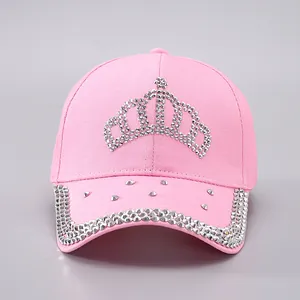 Détail d'une casquette rose en coton avec motif couronne en strass argentés