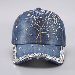Detail of rhinestone spider web pattern on denim baseball cap with crystal brim edge