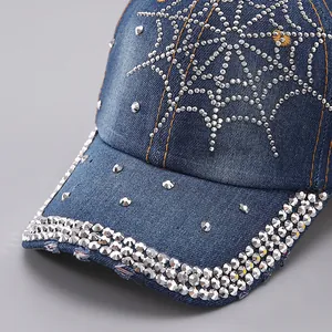 Macro shot of rhinestone spider web pattern and metal studs on denim baseball cap